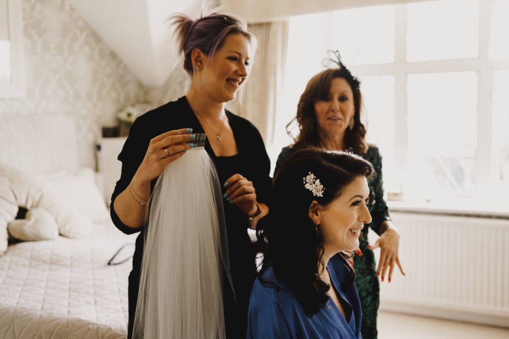 Bride getting ready with her bridal hair and makeup artist on her wedding morning