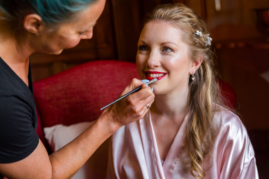 Bridal hair and makeup artist styling a bride on her wedding morning