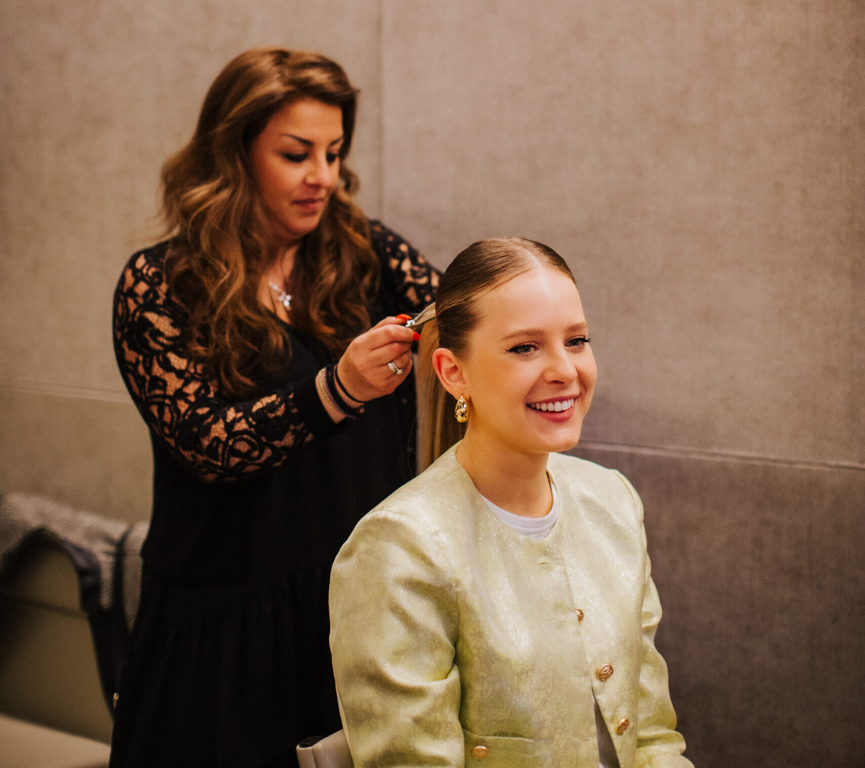 On-set hair and makeup artist preparing talent for corporate filming